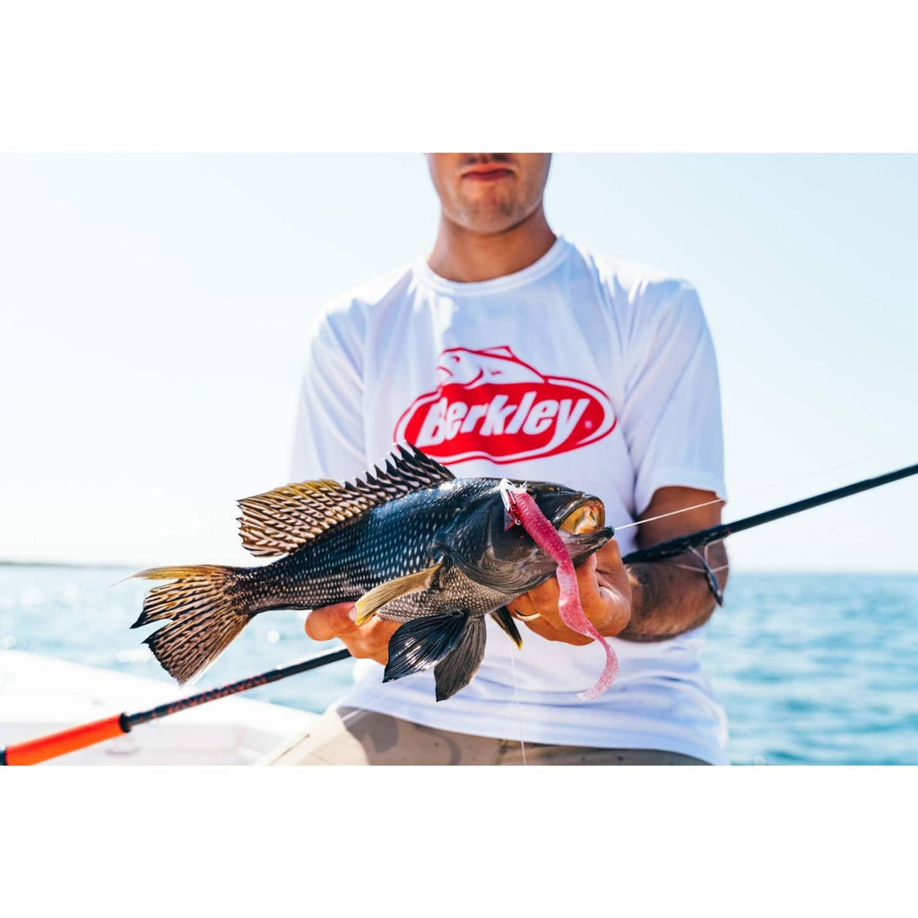 Fish held with pink soft plastic bait on a jig hook