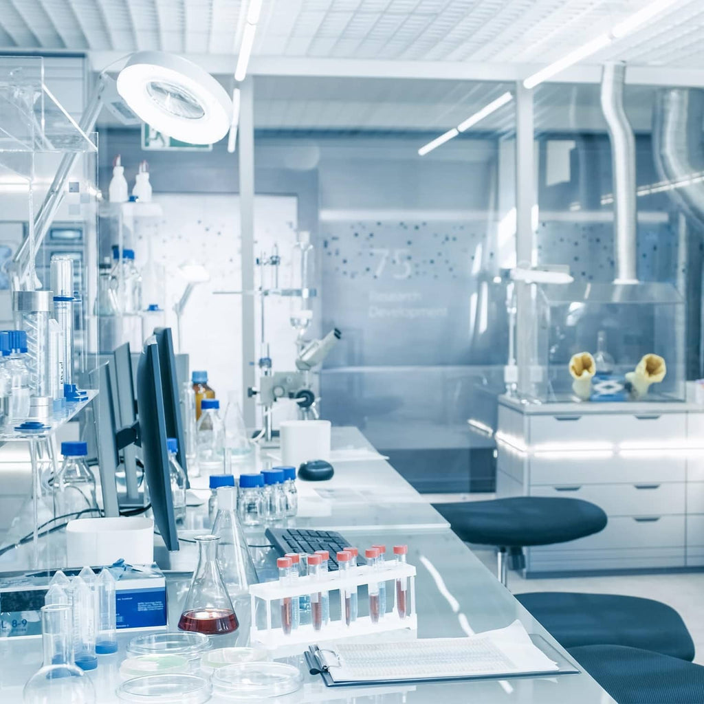 Laboratory workbench with several clear bottles and metal-capped dispensers