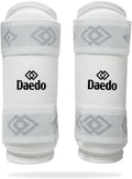 White Taekwondo forearm guards with Daedo logo and elastic strap wraps
