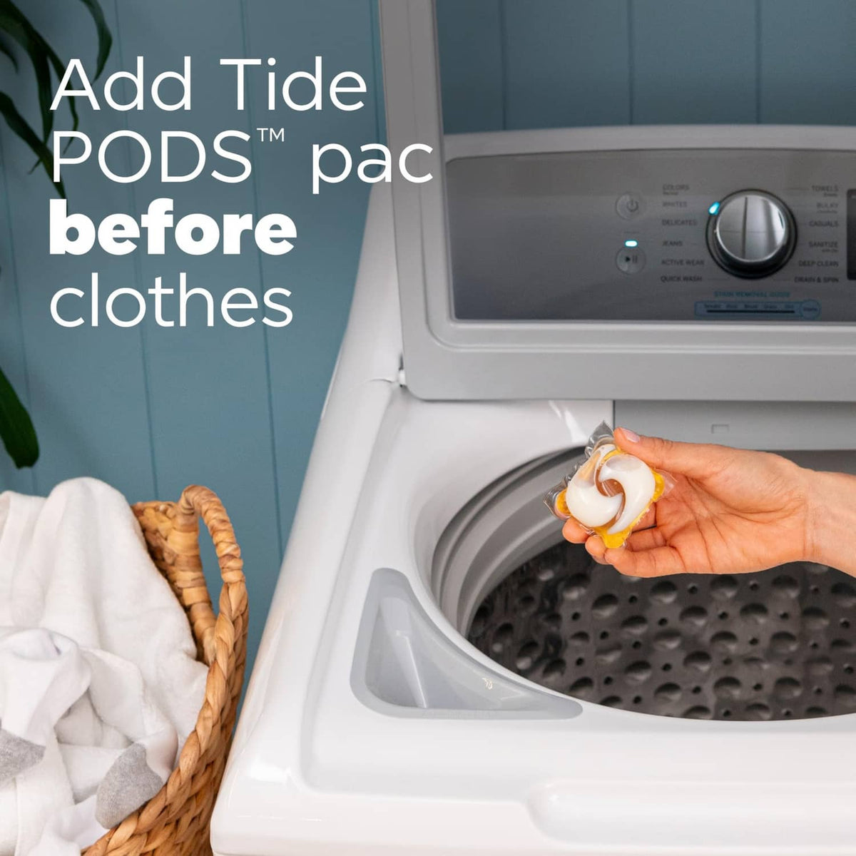 Hand placing a Tide PODS detergent pod into a front-load washer drum