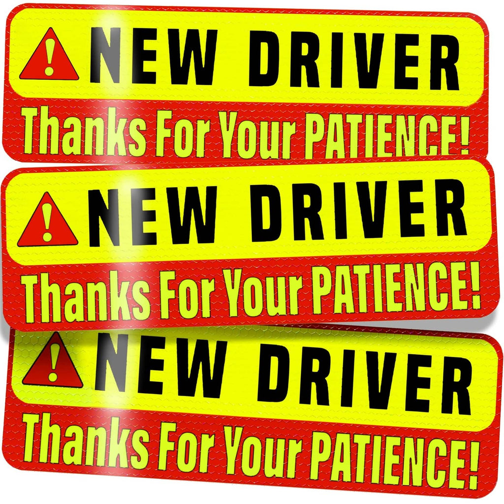 Close-up of stacked “New Driver” magnetic signs with red warning border.