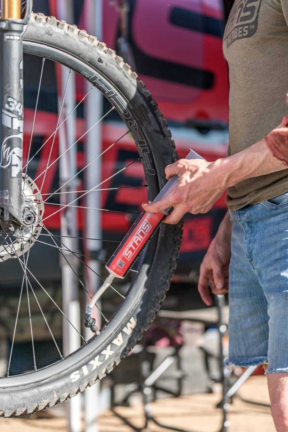 Tubeless sealant injector dispensing near a bicycle tire bead during installation