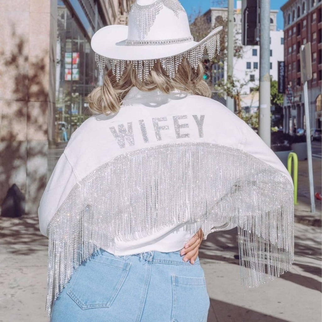 Silver rhinestone letter patch spelling WIFEY on a white top hat with fringe