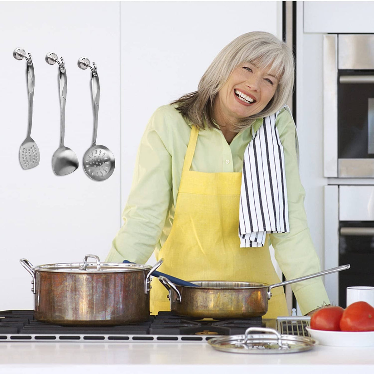 Stainless magnetic hooks holding kitchen utensils on a cabinet surface