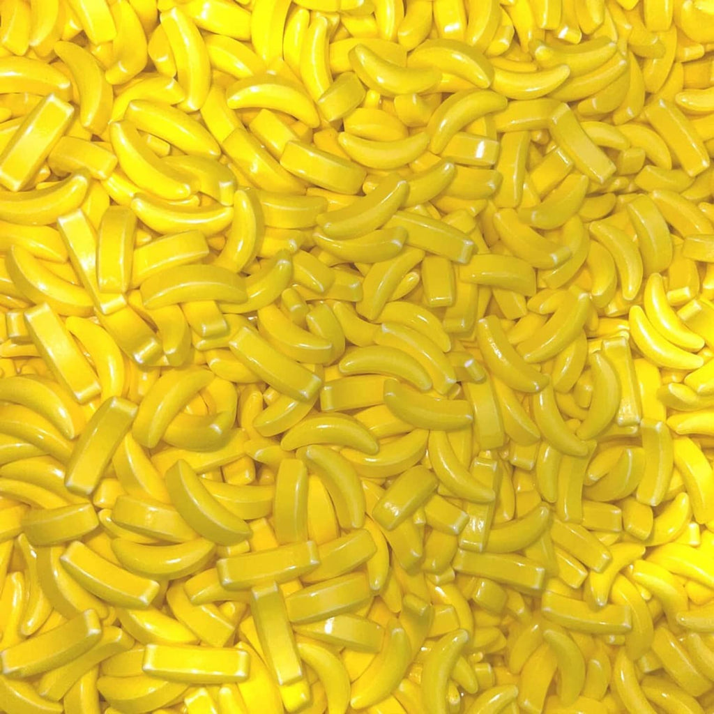 Banana-shaped yellow candy pieces, small curved bites in bulk