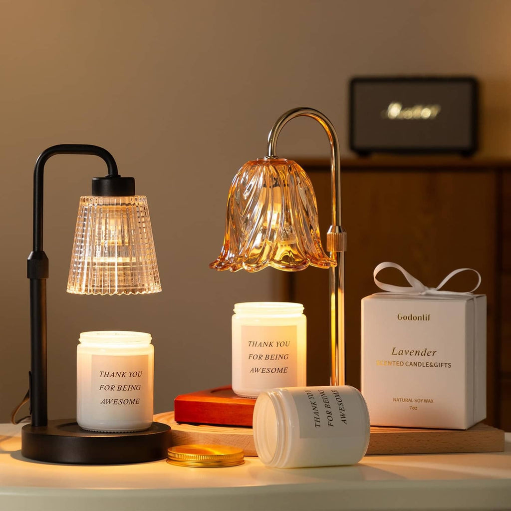 Gold and black flameless candle lamps with glass flower shades and lit jar candle