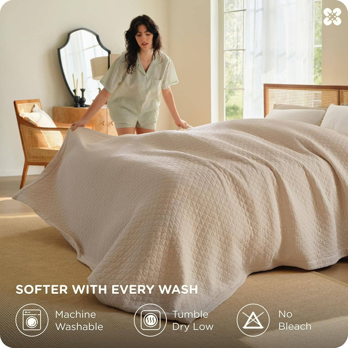 Cream cotton muslin blanket spread on a bed, textured quilted weave with stitched edge