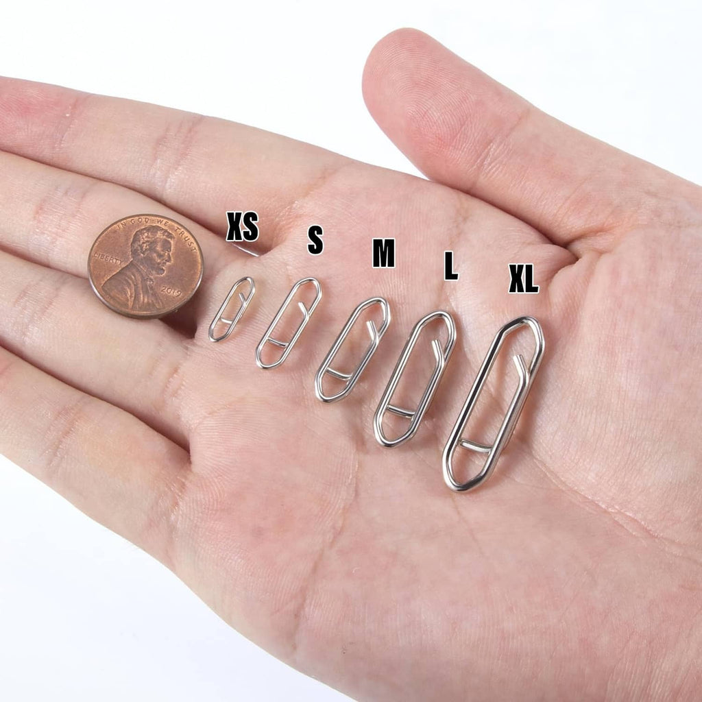 Assorted fishing speed clips in multiple sizes, shown on an open hand with coin
