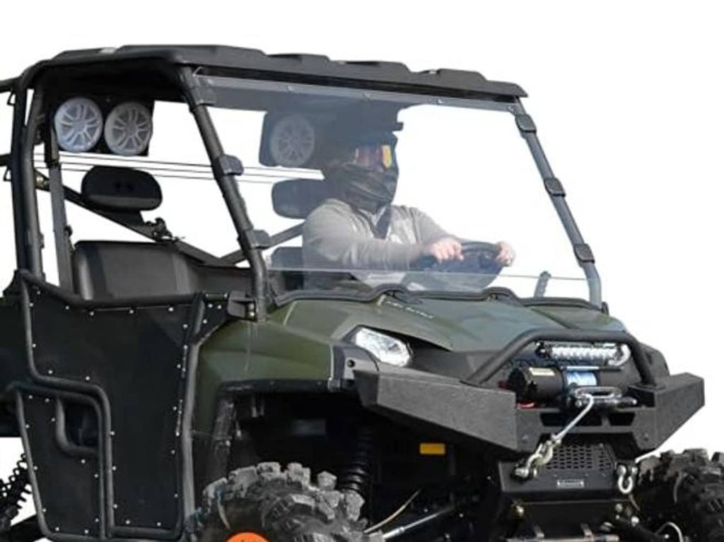 Front 3/4 view of clear full windshield on green UTV with steering wheel and driver