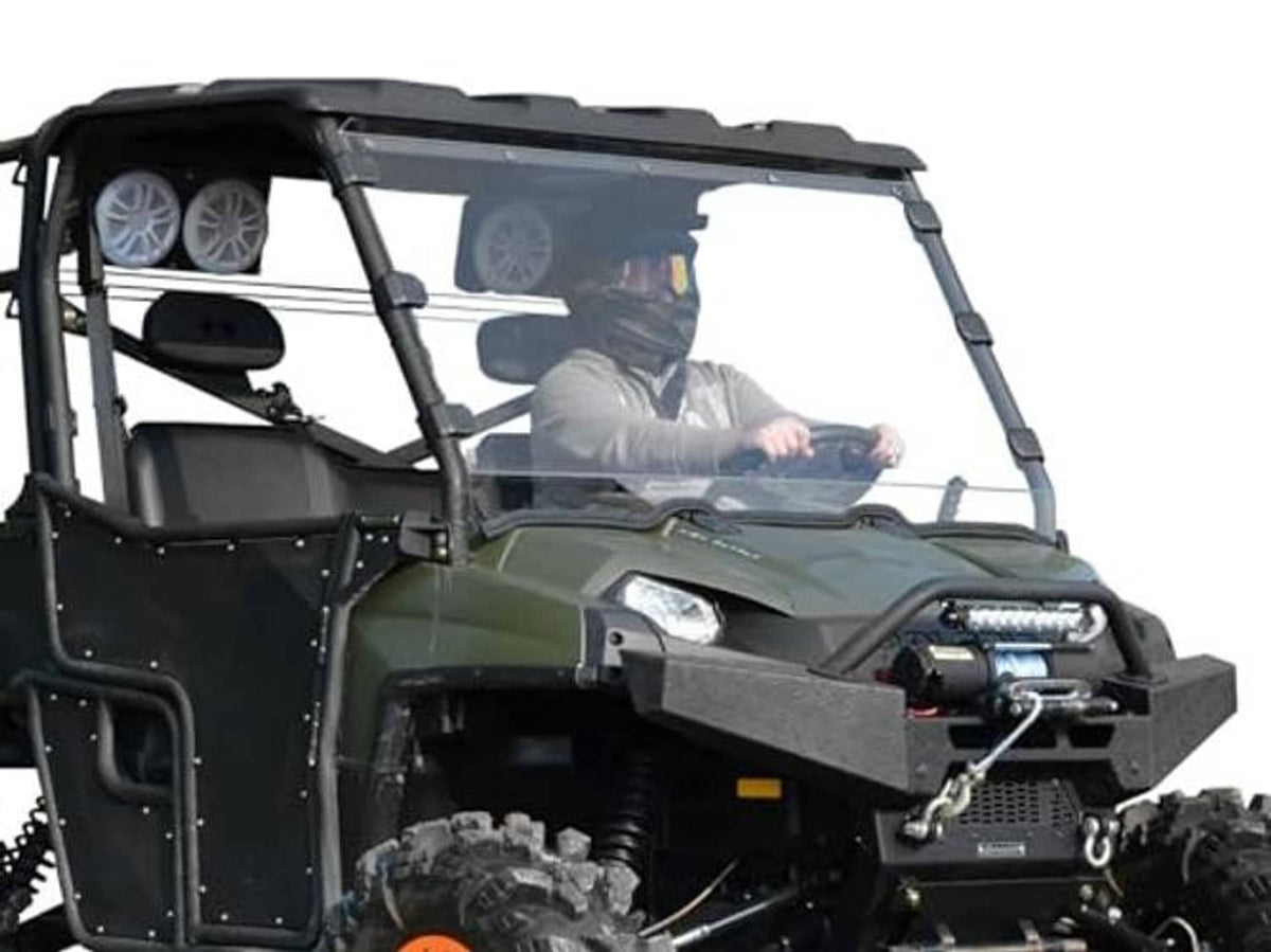 Front 3/4 view of clear full windshield on green UTV with steering wheel and driver