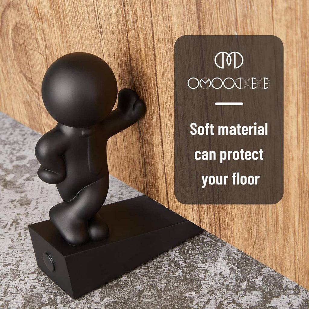 Black decorative door stop figurine with curved arms on a flat rectangular base.
