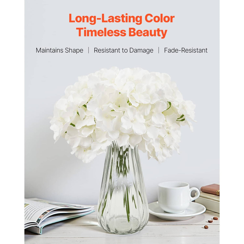 Artificial white hydrangea bouquet in clear glass vase with green stems