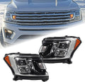 Pair of black headlight assemblies with clear lenses and amber turn signal markers