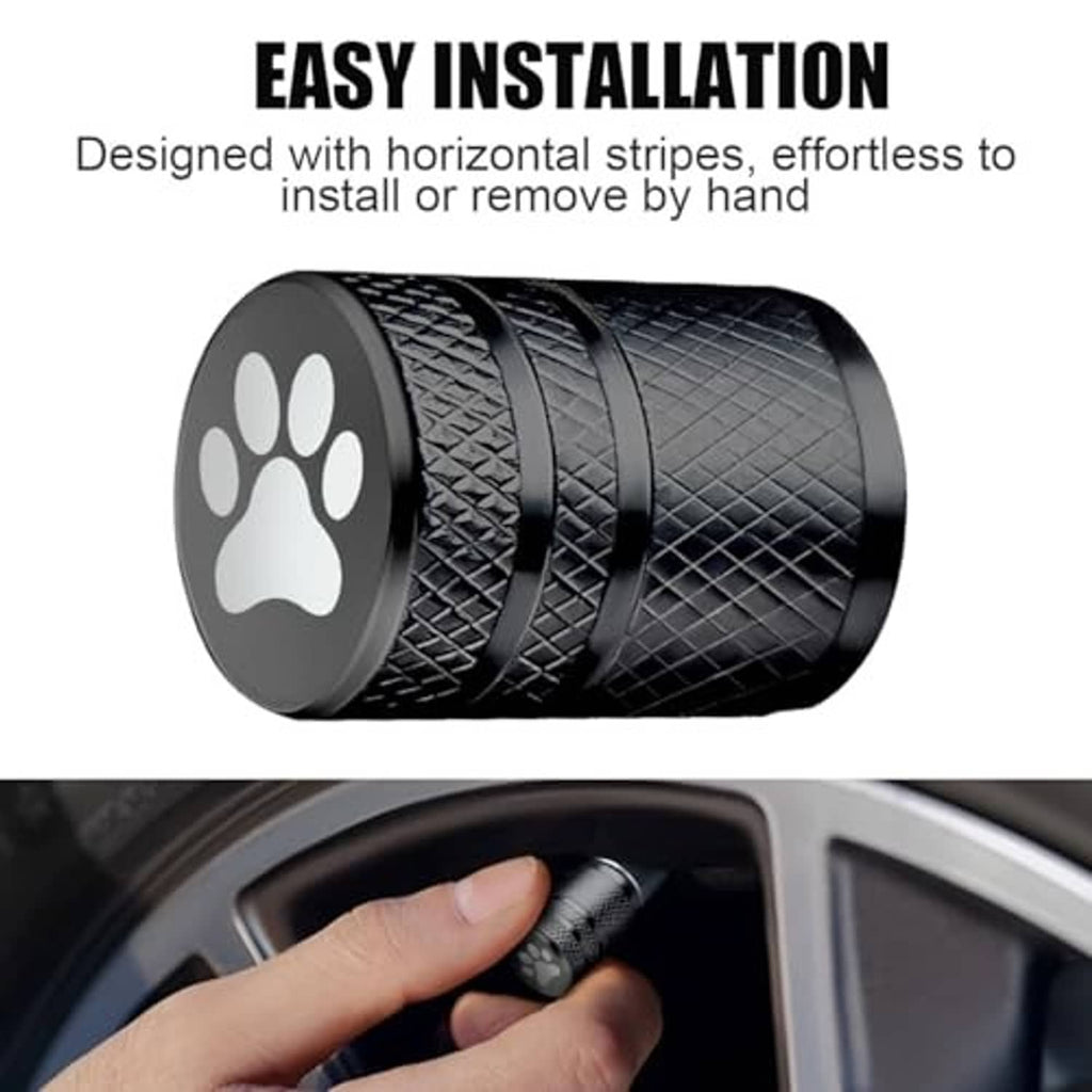 Black cat-paw tire valve stem cap with textured sides, shown with hand near wheel