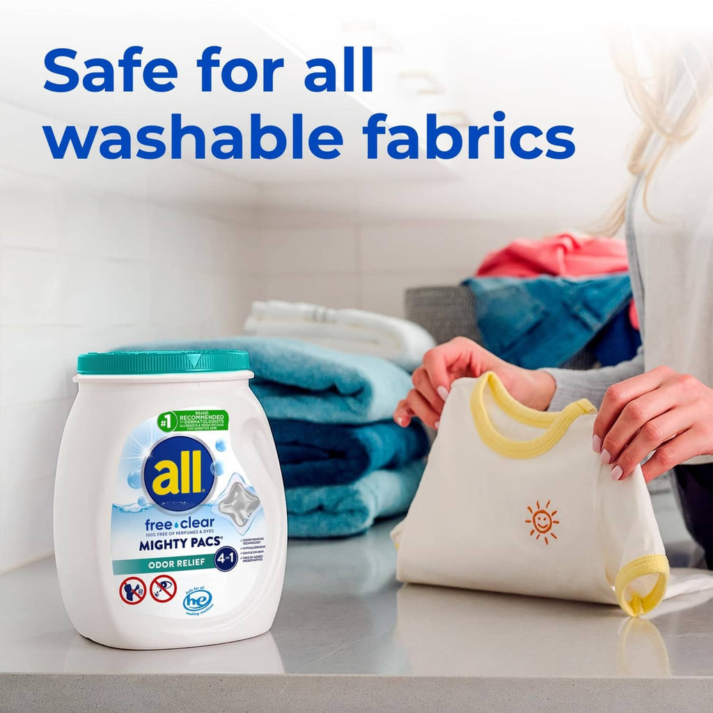 all free clear Mighty Pacs detergent jar with teal cap beside soft clothes