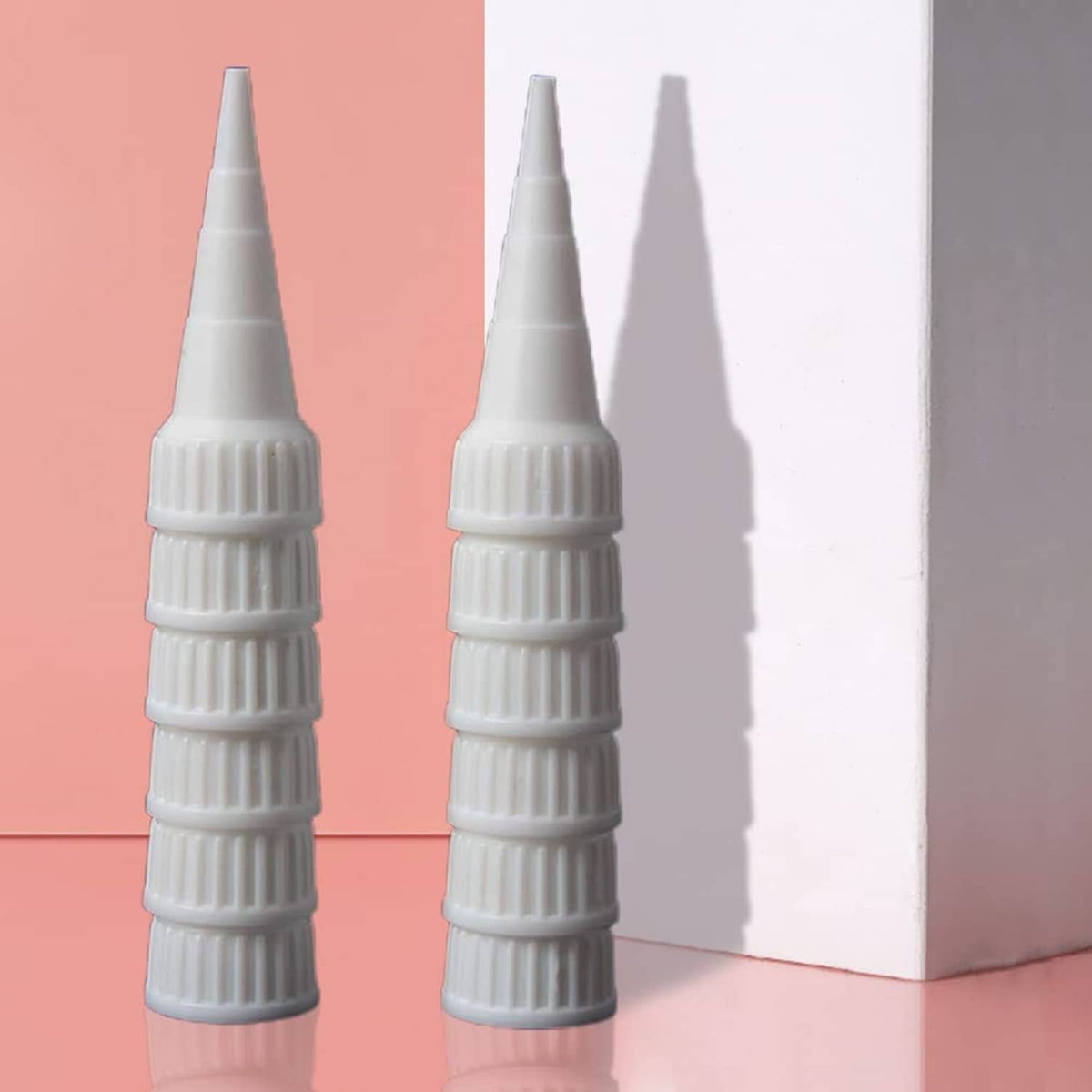 Two white snip-tip applicator caps, ribbed grip and conical nozzle