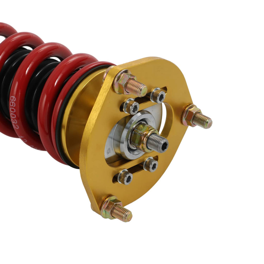 Coilover strut with red spring and gold top hat, showing mounting bolts and plates