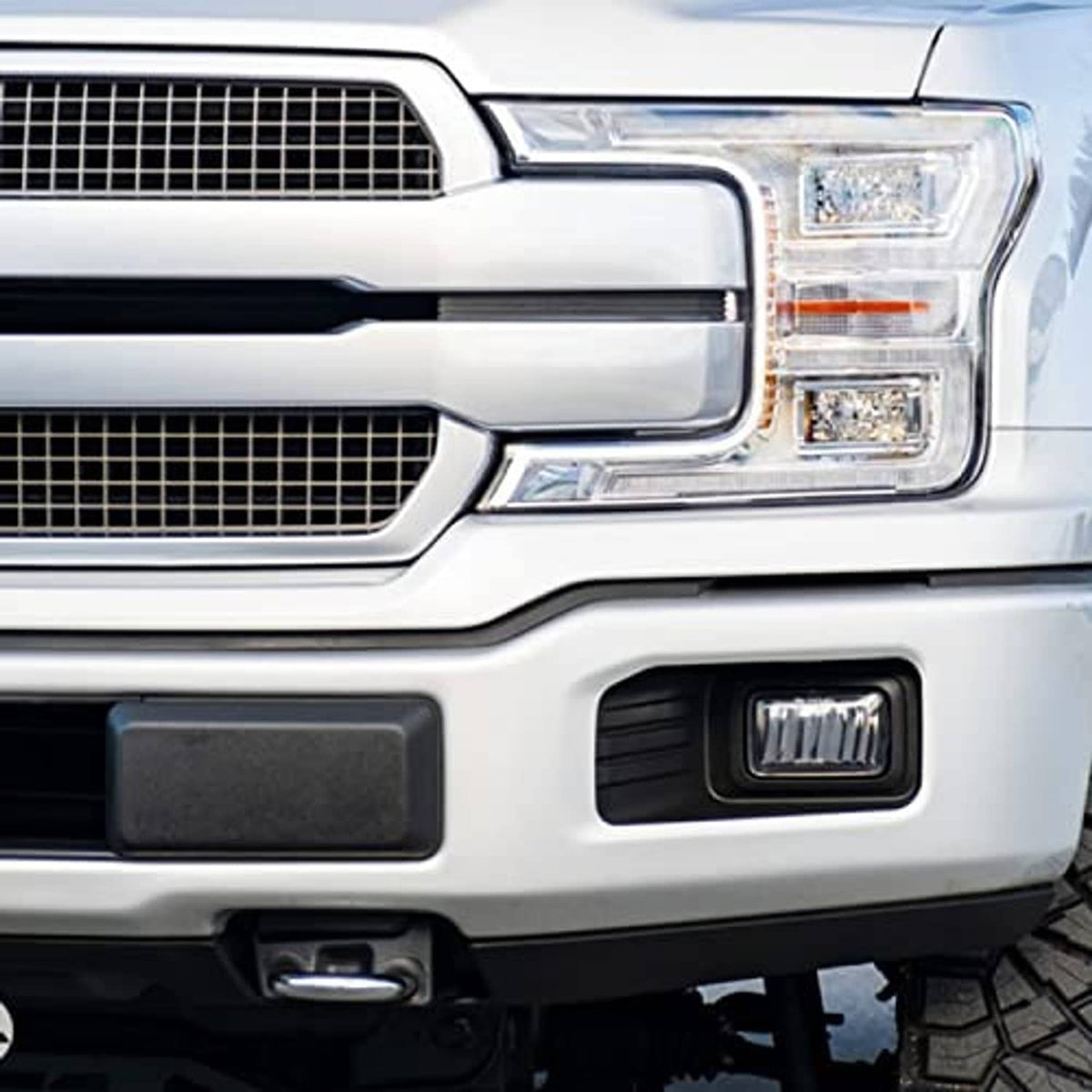 Front bumper guard pad installed on white truck bumper near grille