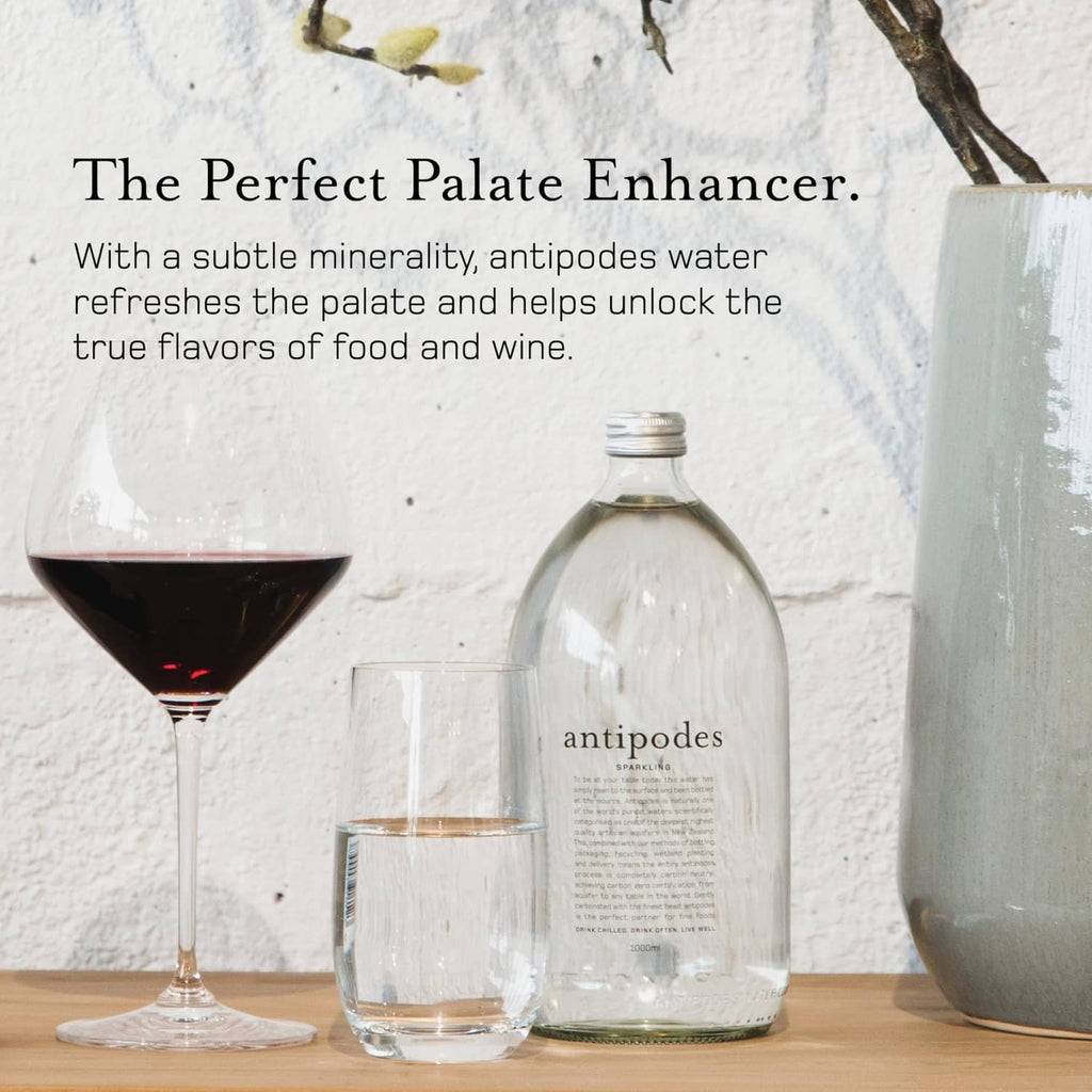 Antipodes sparkling water bottle with two glasses, clear glass and metal cap