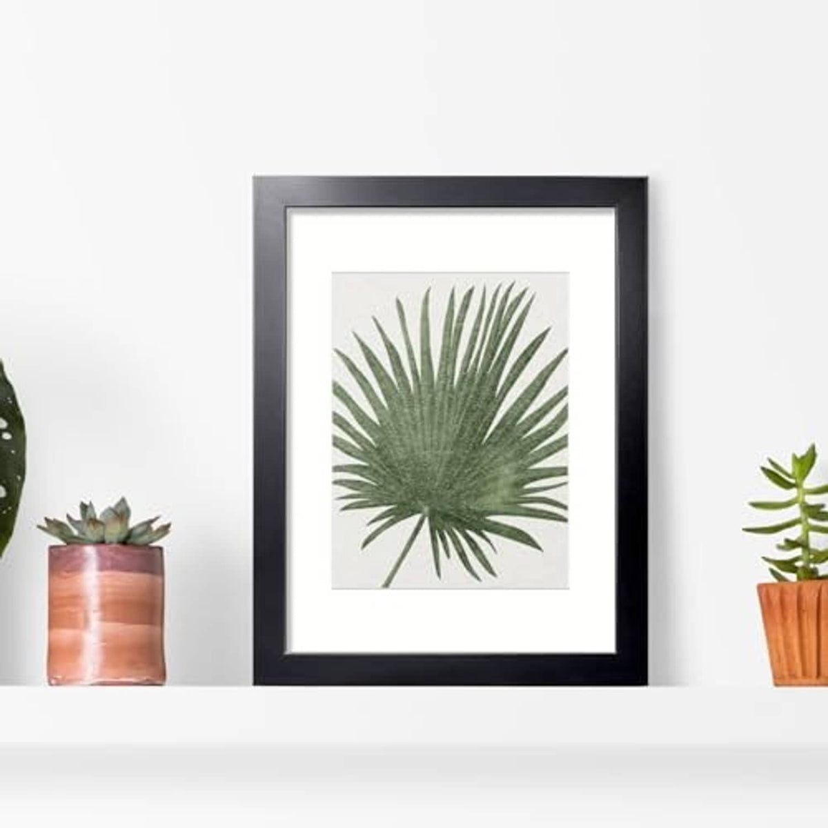 Black 11x14 picture frame displaying a green palm leaf print