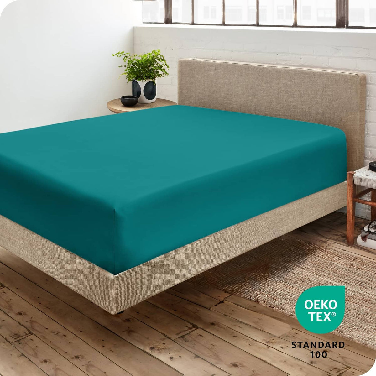 Teal green fitted sheet on a bed with fitted flat top surface
