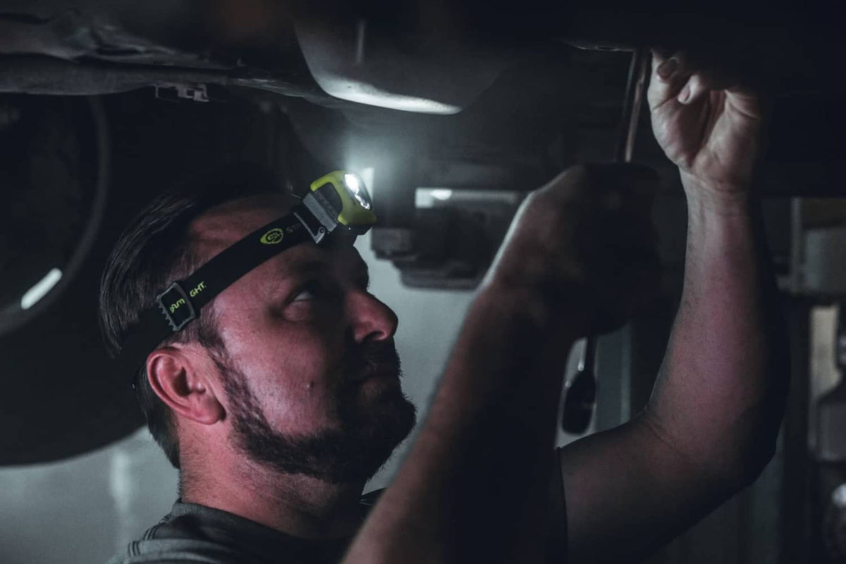 Yellow headlamp worn on a worker with a black strap and mounted light module