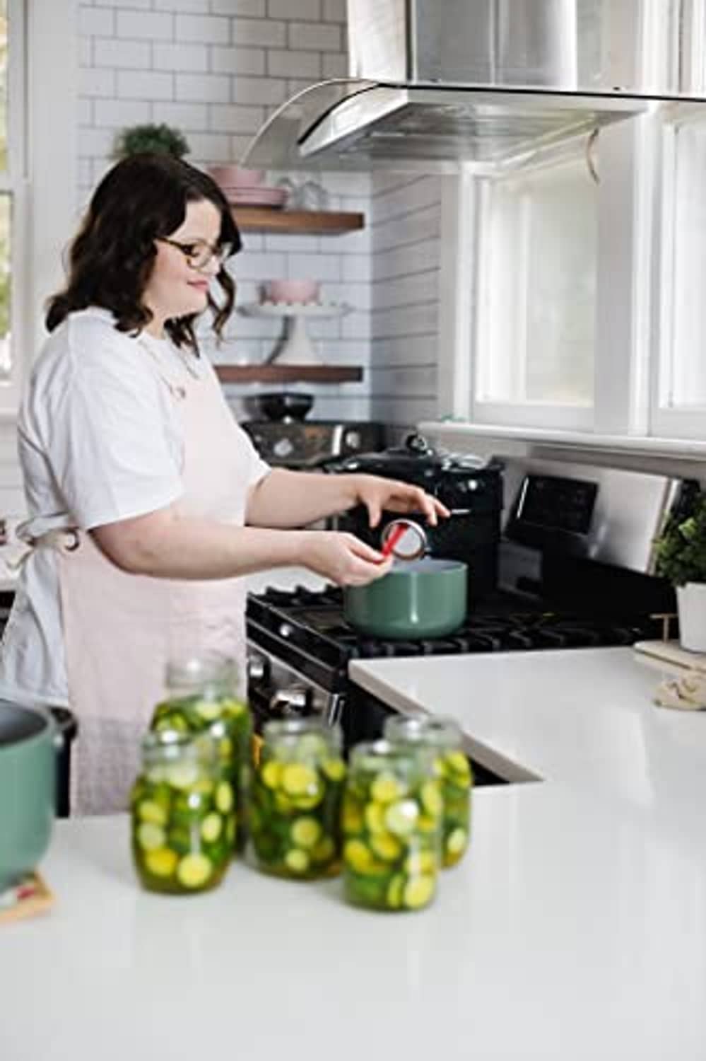 Pickle mix packet and jars in a home kitchen with a stove in the background