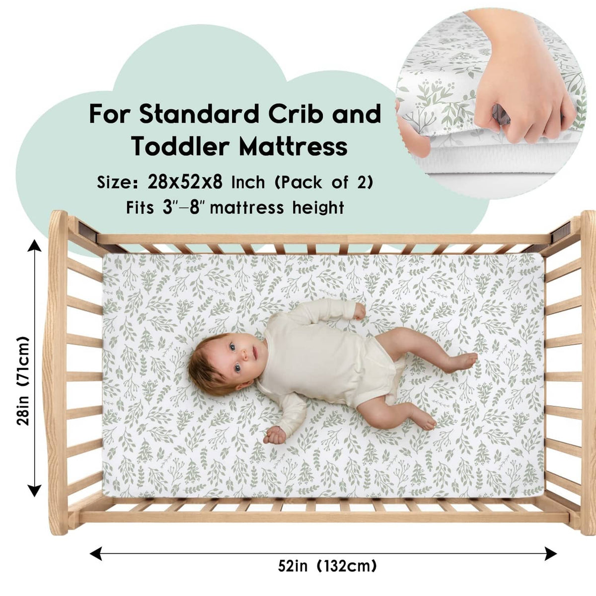 Fitted crib sheet with white base and green leaf pattern, shown on a standard crib mattress