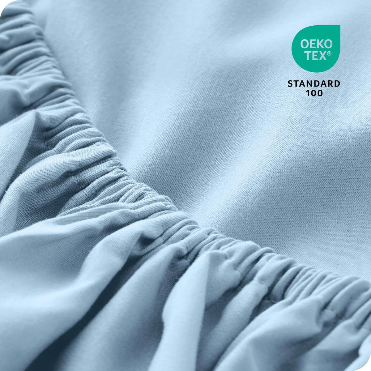 Light blue fitted sheet close-up showing gathered elastic hem