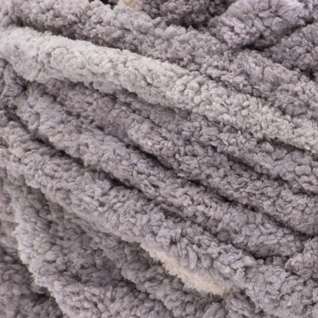 Gray chunky knit yarn texture close-up, thick loops and ribbed ridges