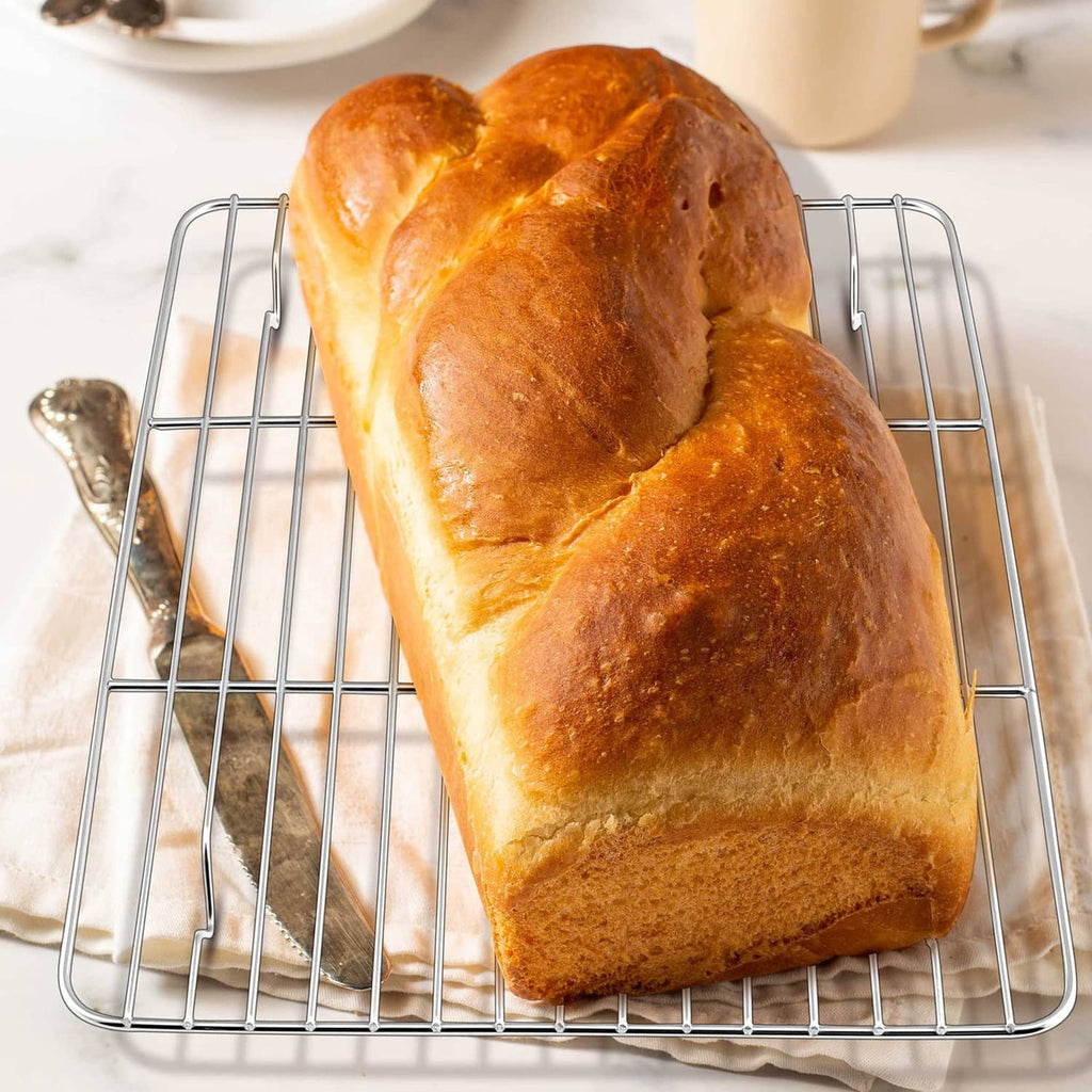Mini stainless steel cooling rack set of 2 holding a baked bread loaf on wire grid