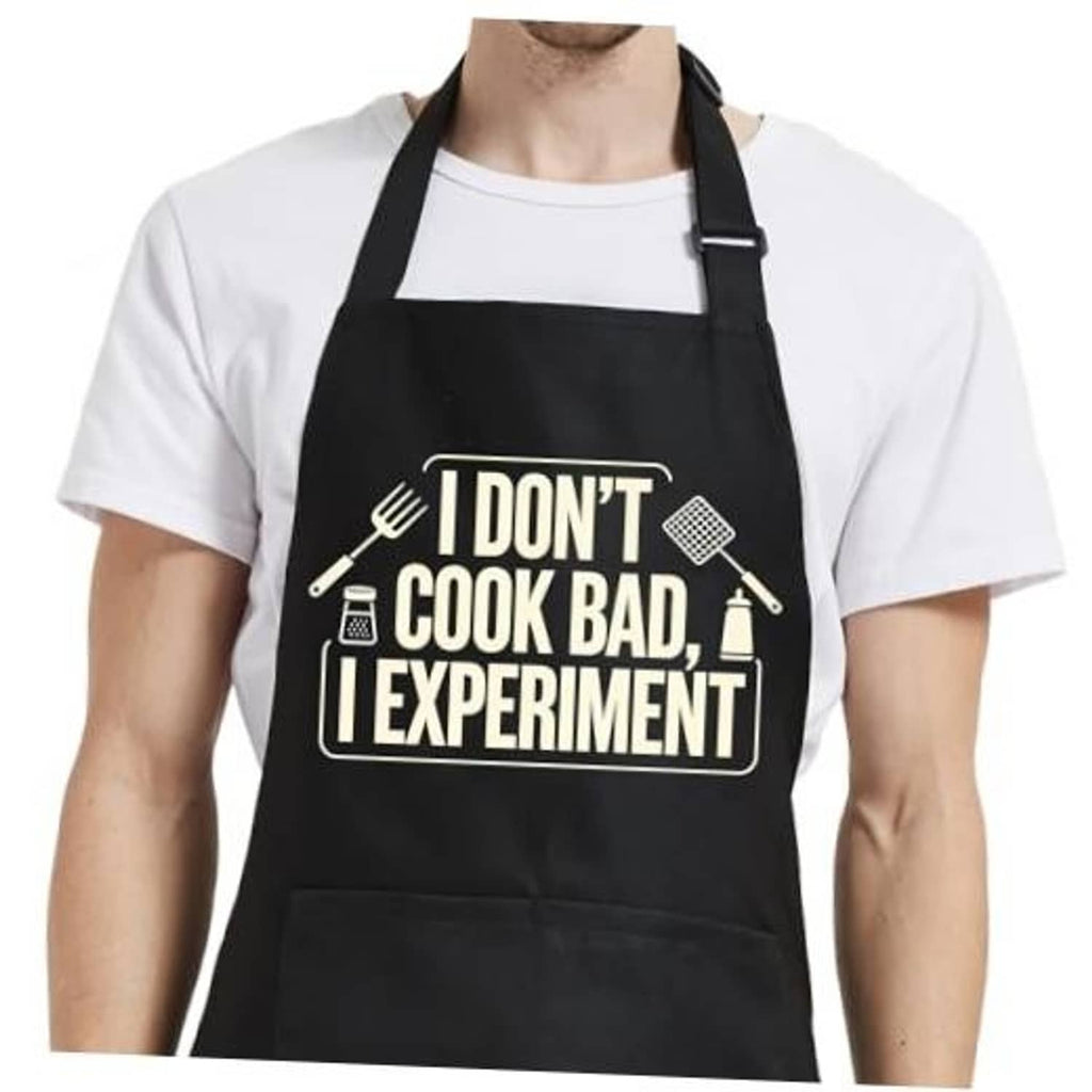 Black cooking apron with front graphic text, adjustable neck straps, and two long waist ties