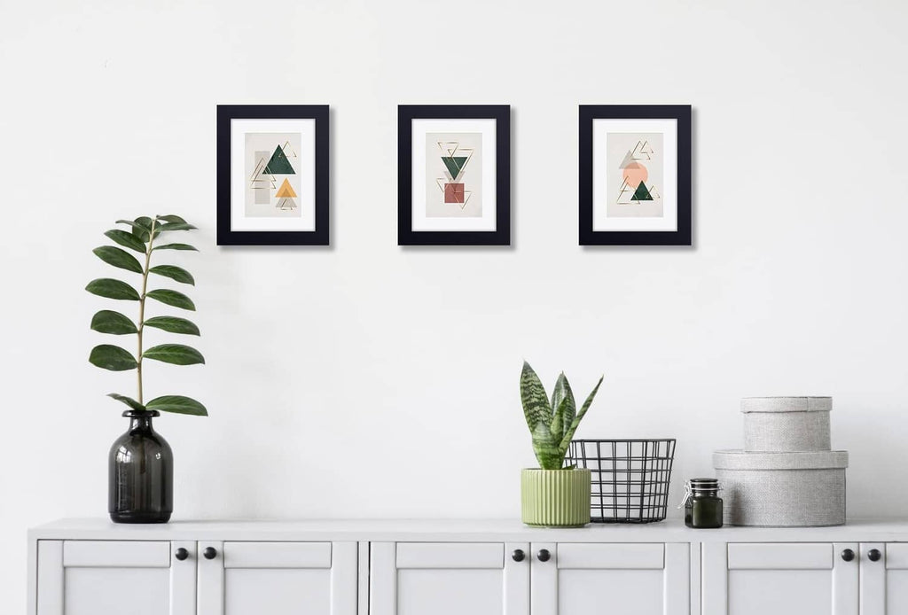 Set of small black picture frames displaying photos on a wall