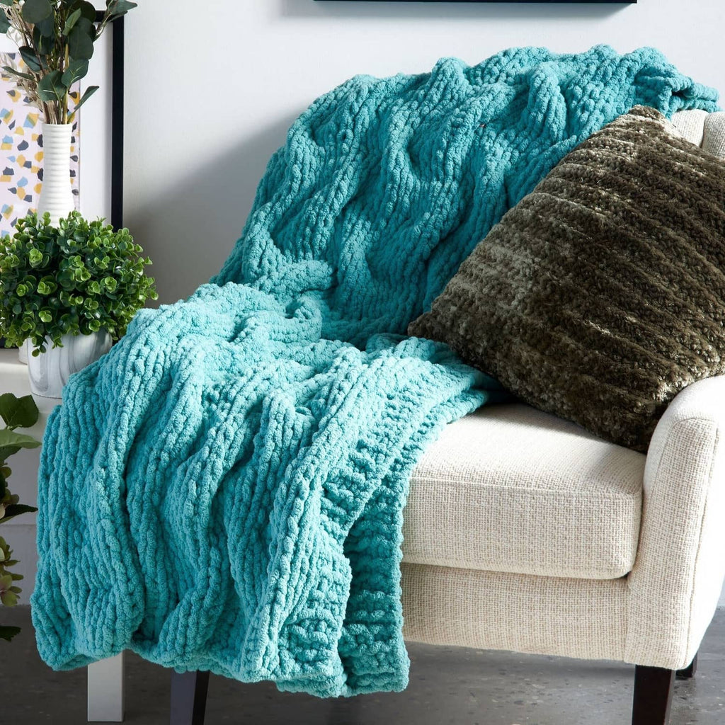 Chunky chenille throw blanket in teal with a dark gray accent pillow