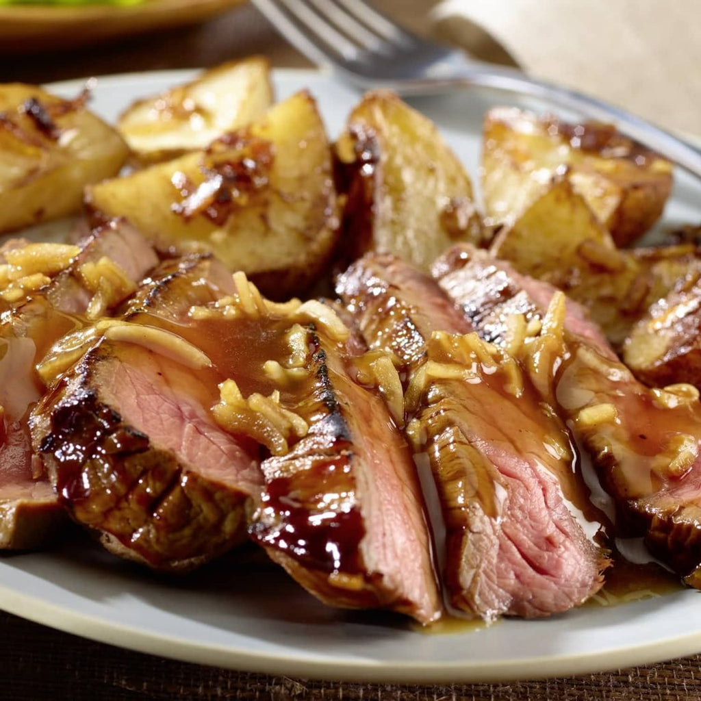 Sliced roast beef with brown au jus gravy and caramelized onion topping
