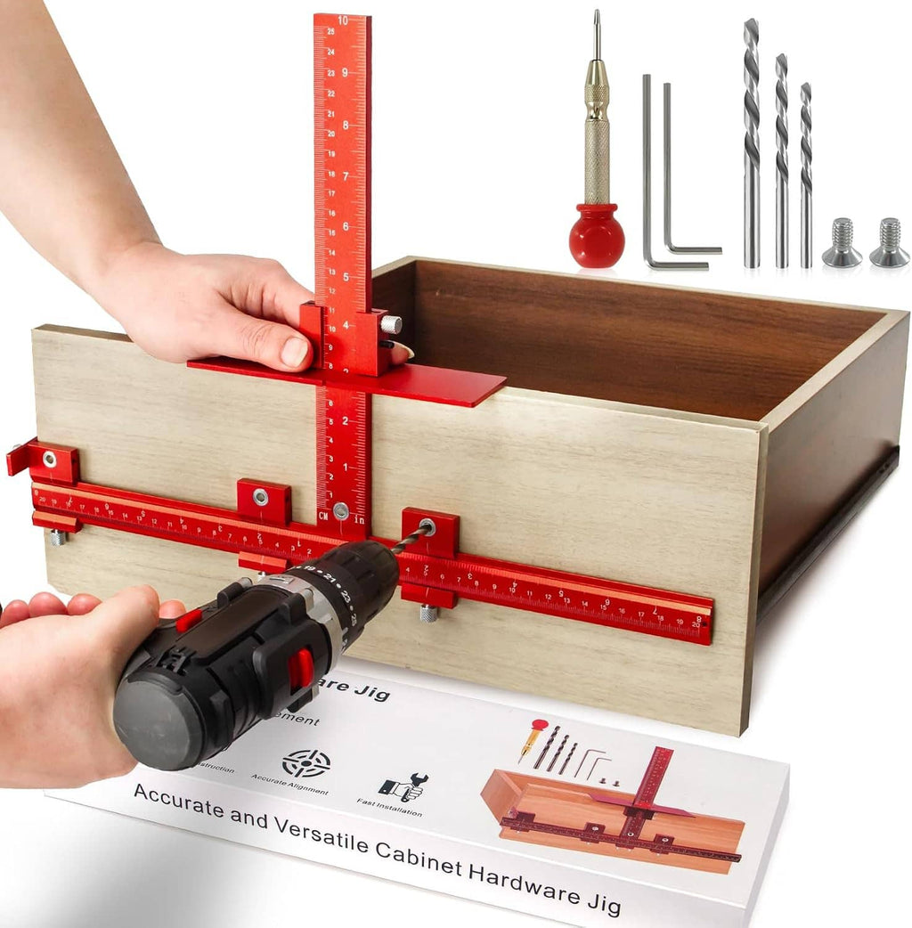 Cabinet handle jig with red guide rail mounted on wood cabinet panel, drill being used