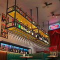 Ceiling wine glass rack with dark metal frame, acrylic shelves, and hanging wine glasses