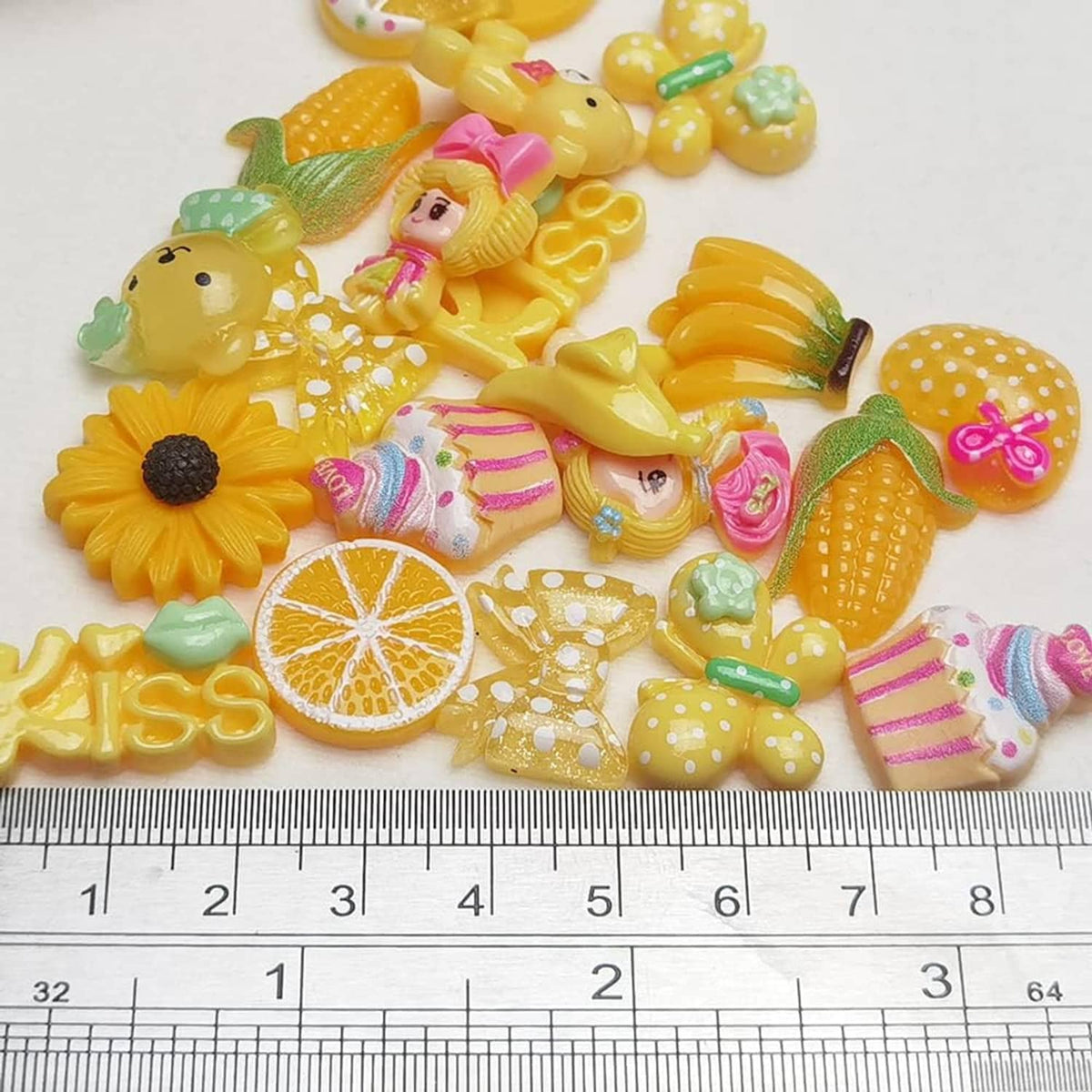 Yellow flatback resin buttons with a sunflower and lemon slice, next to a ruler