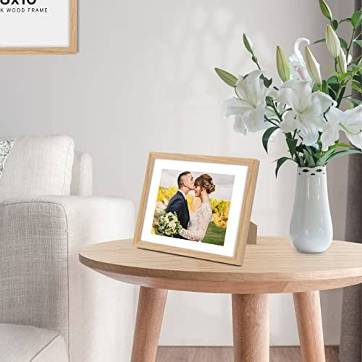 Natural oak wood picture frame on table, holding a family photo print