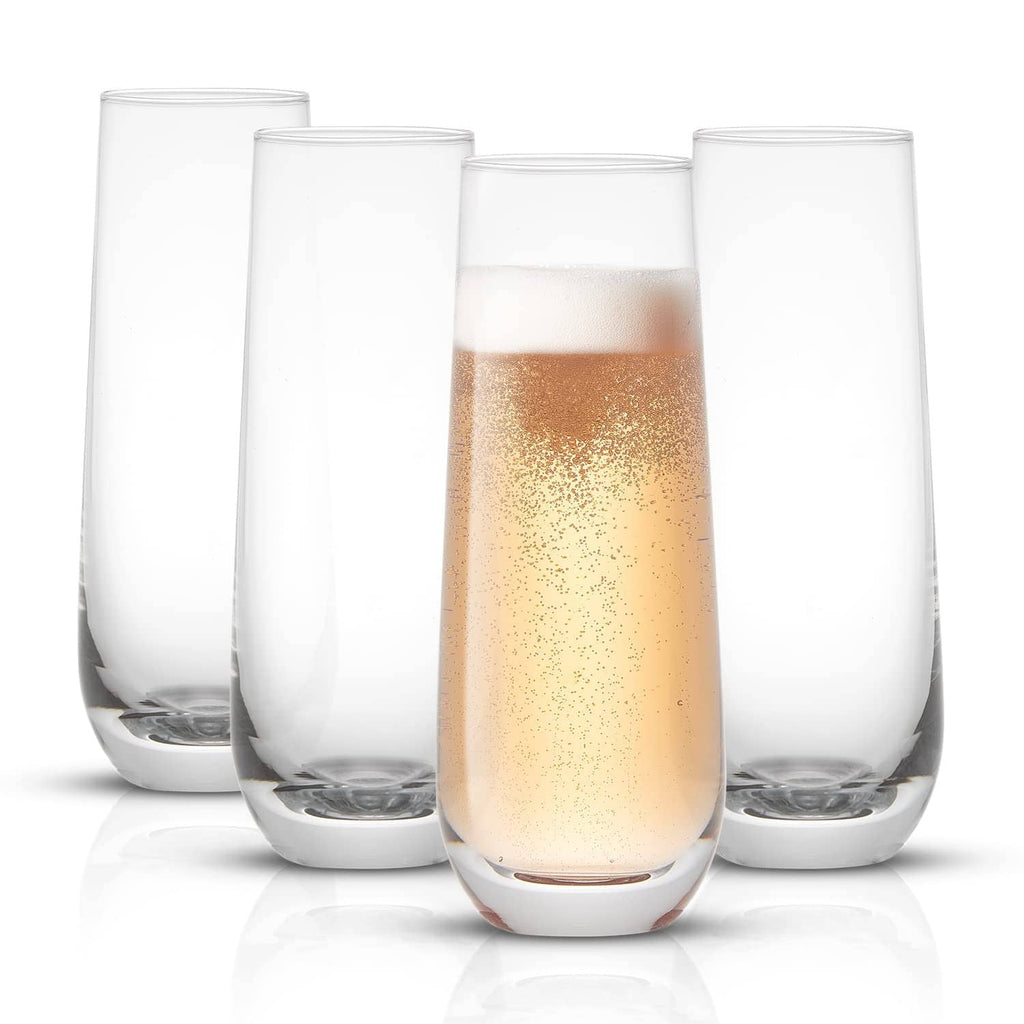 Set of 4 stemless champagne flutes, clear glass, filled with golden sparkling drink