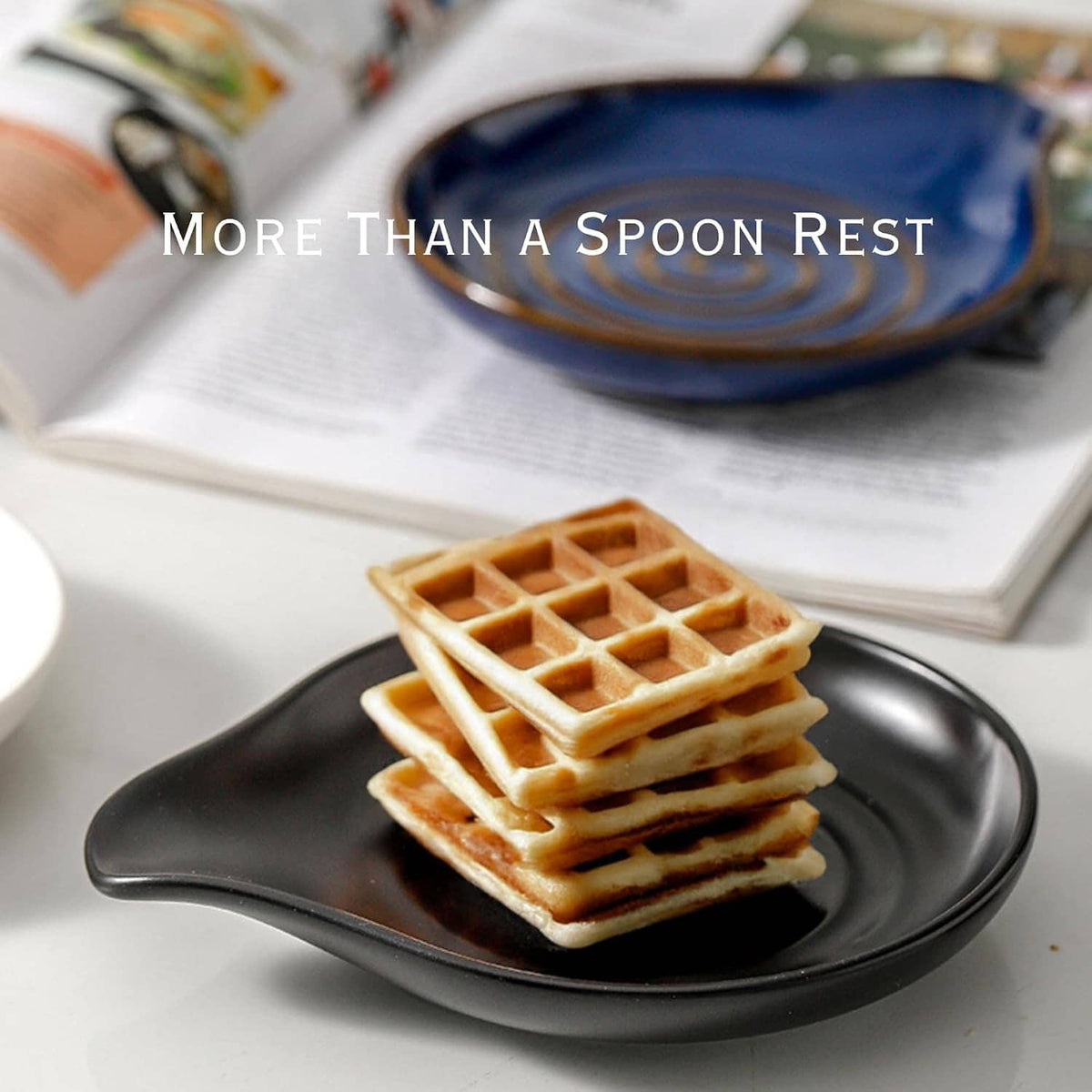 Black ceramic spoon rest with a brown wooden spatula holding waffle pieces