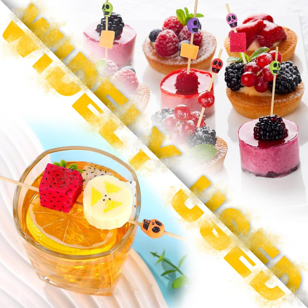 Colorful bamboo skull toothpicks inserted in fruit bites and desserts on a plate