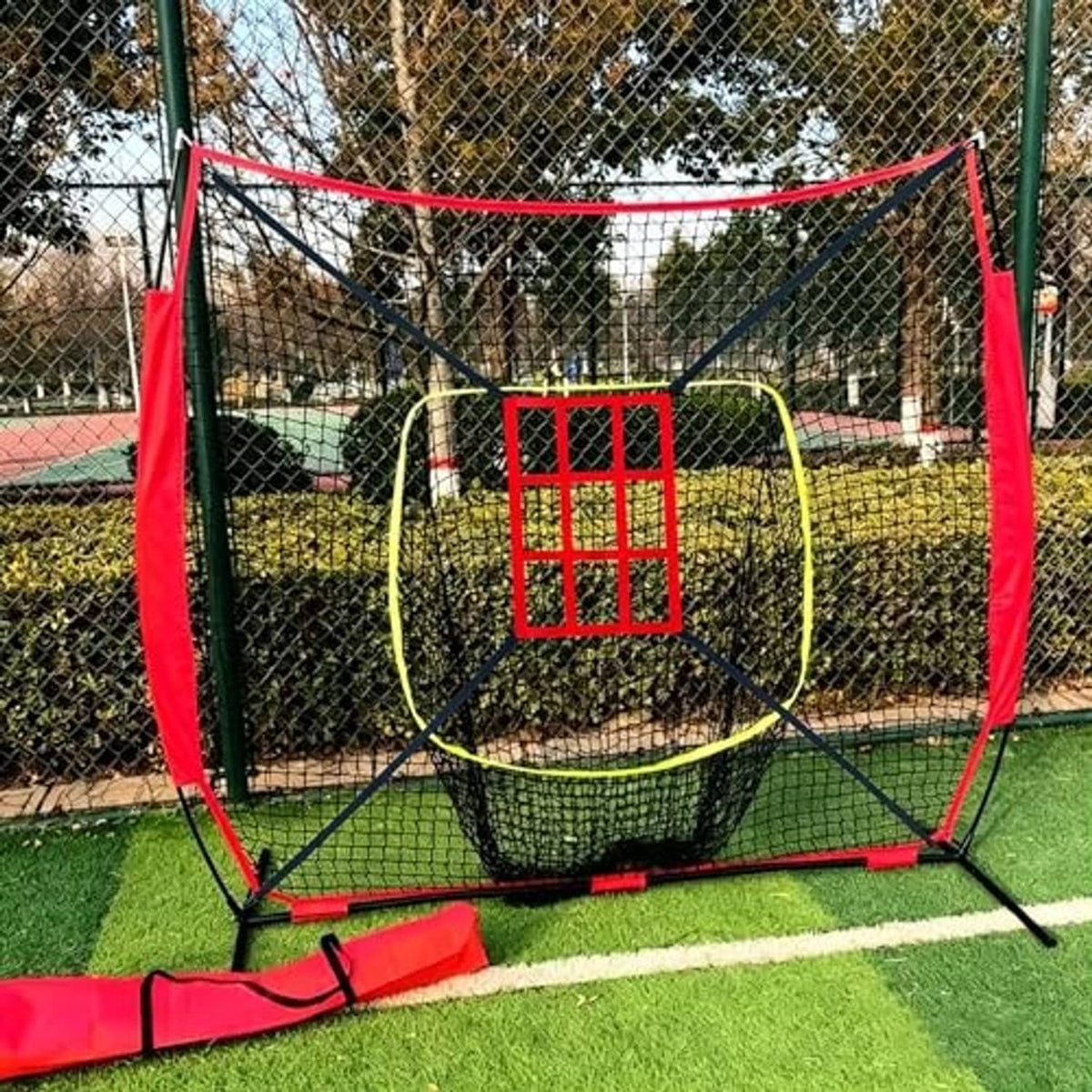 Outdoor strike zone target net with red-framed grid window and surrounding netting