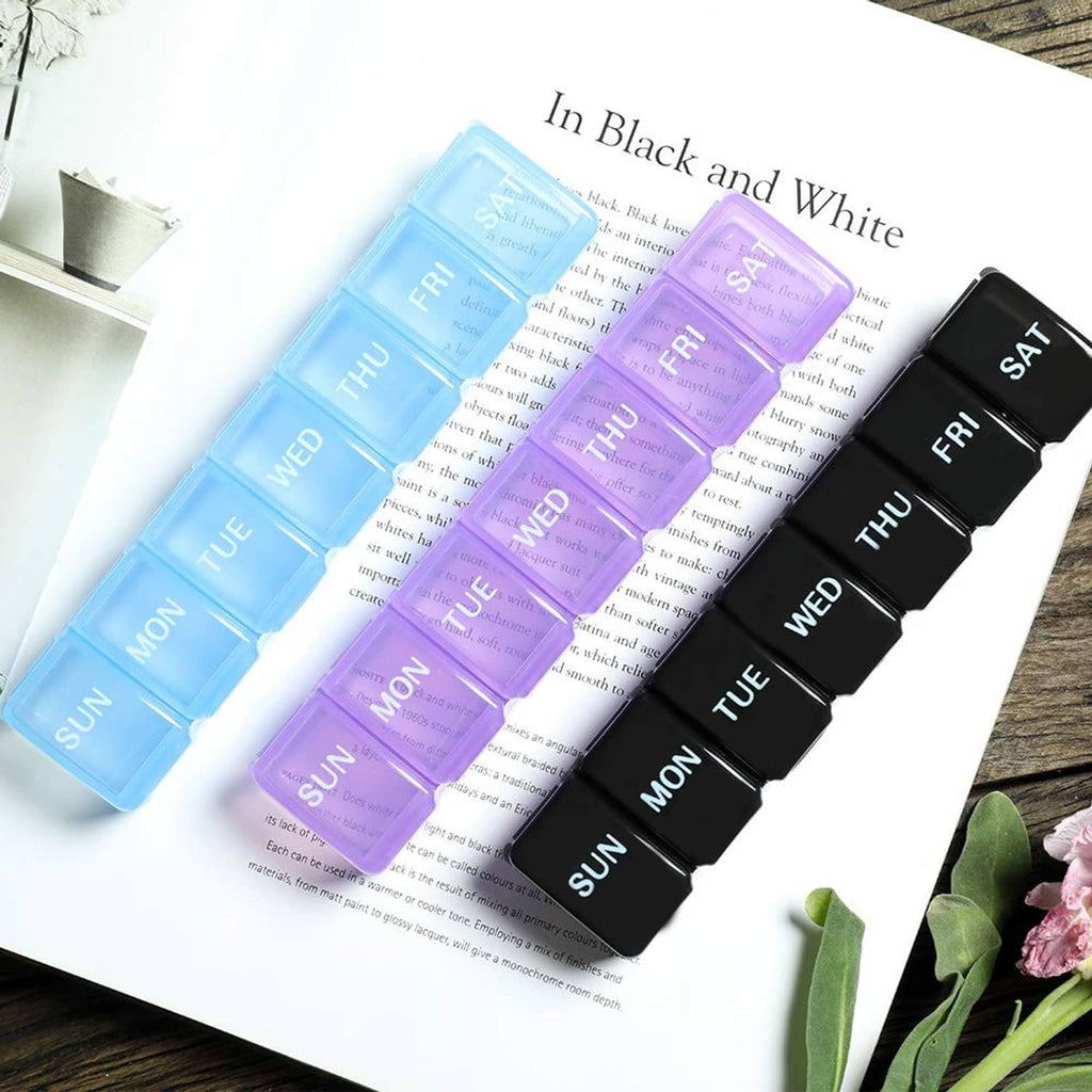 Two-pack weekly pill organizer set in black and white, day labels Mon–Fri and SAT