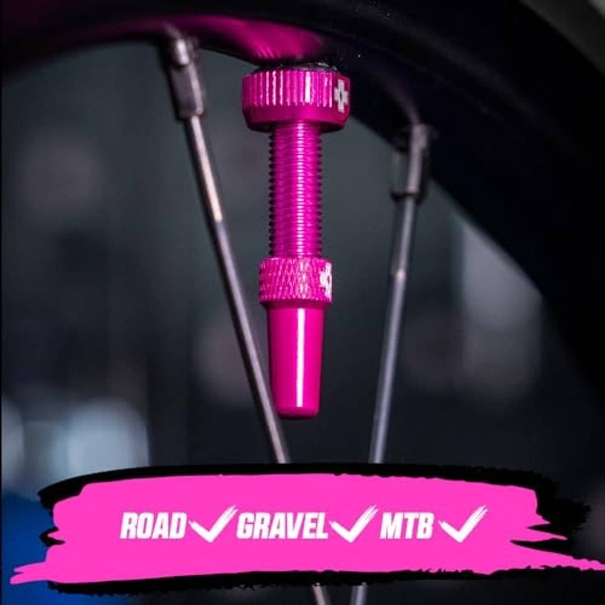 Pink Presta tubeless valve installed on tire, showing textured barrel and top