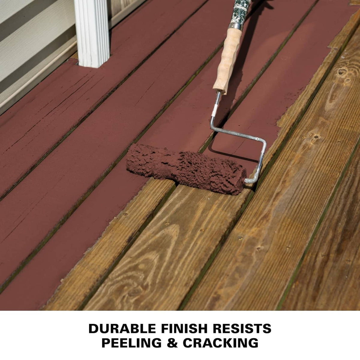 Coating roller painting reddish-brown finish on wooden deck boards