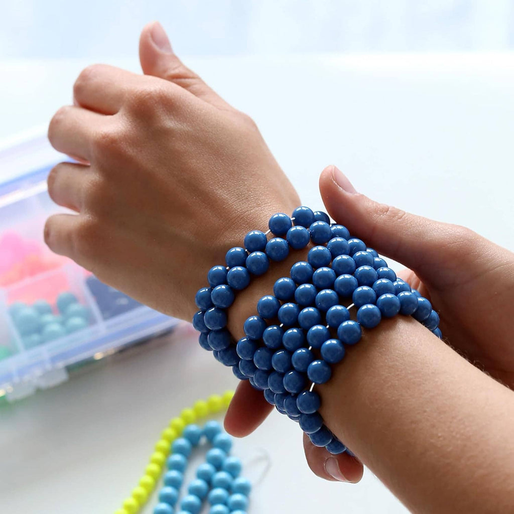 Elastic bead cord bracelet on wrist with blue beads and clear cord