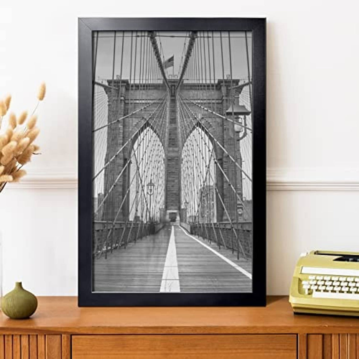 Black picture frame holding a black-and-white bridge photo