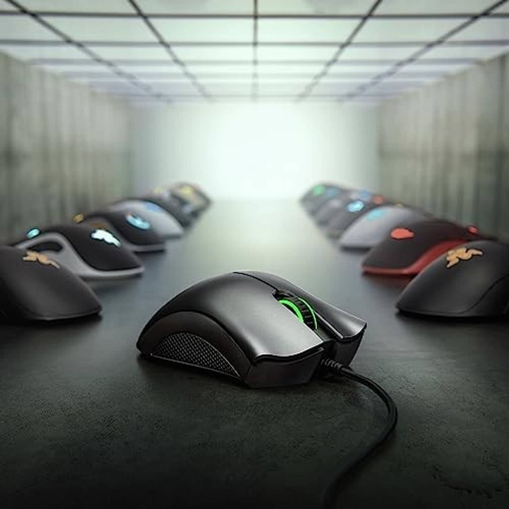 Black wired gaming mouse with glowing RGB accents and textured side grips on mat.
