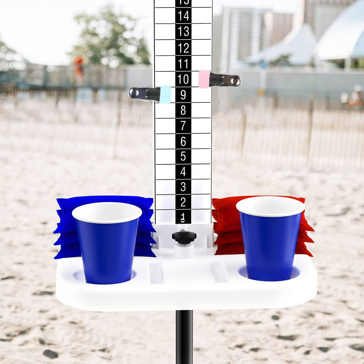 Cornhole scoreboard set on sand with tall numbered panel, two cup holders, and tables